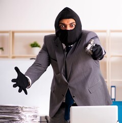 Male gangster stealing information from the office