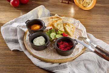 Assorted Spreads and Dips with Toasts on a Rustic Wooden Serving Board