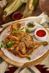 Grilled Chicken Tabaka with Red and White Sauces on Wooden Platter