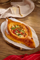 Traditional Khachapuri with Tomatoes on Rustic Wooden Table