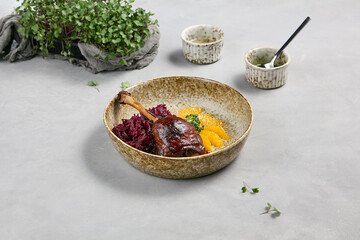Duck Leg Confit with Red Cabbage and Orange in Rustic Bowl