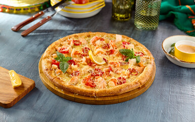 Salmon and Tomato Pizza on Wooden Board with Lemon Wedge and Basil Garnish