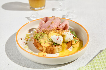 Delicious Brioche Bun with Ham, Poached Egg, and Hollandaise Sauce - Gourmet Brunch Presentation