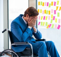 Young handsome man in wheelchair with many conflicting prioritie
