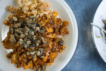 Phuket traditional food called O-tao mixed with oysters, steamed taro and eggs served with pork kappa and eating with spicy sauce, found only in Phuket Thailand. Phuket local street food