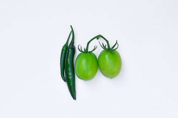 Green chilies and green tomatoes isolated on white background