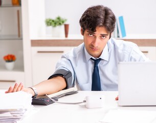 Fototapeta premium Man under stress measuring his blood pressure