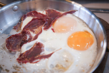 Delicious Fried Eggs with Crispy Bacon Cooked Perfectly in a Pan for a Tasty Meal
