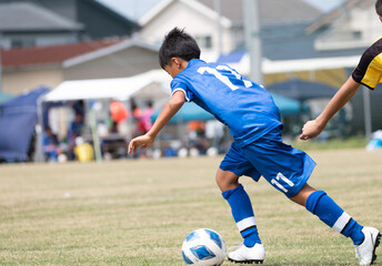 サッカーの試合をする小学生の男の子
