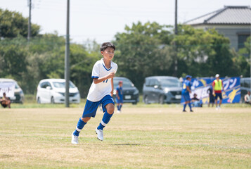 サッカーの試合をする小学生の男の子