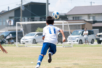サッカーの試合をする小学生の男の子
