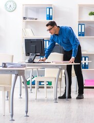Handsome businessman employee sitting at his desk in office