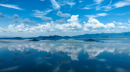Mirror-like reflections on Lake Cuitzeo, Michoacán: A serene fusion of blue sky, puffy clouds, and...
