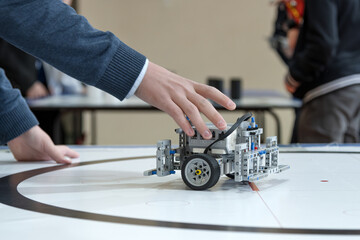 The student stops the robot with his hand, testing the robot