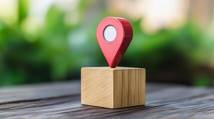 A close-up of a red location pin on a wooden block, symbolizing navigation and discovery in a natural setting.
