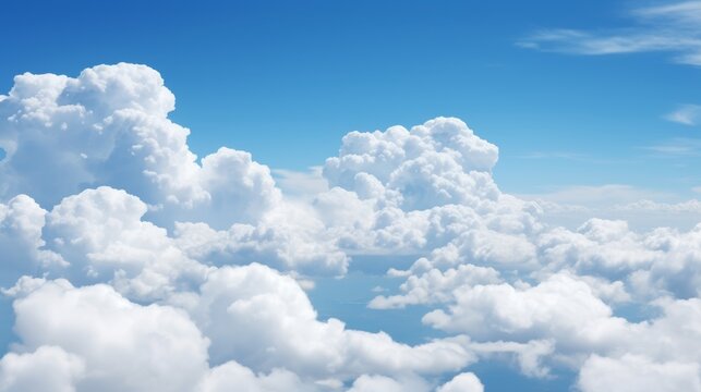 Puffy cumulus clouds in a bright blue sky with plenty of room for copy