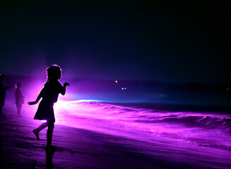 ライトアップされた海と少女のシルエット