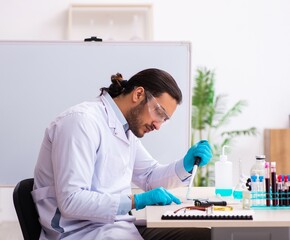 Young male chemist working in the lab