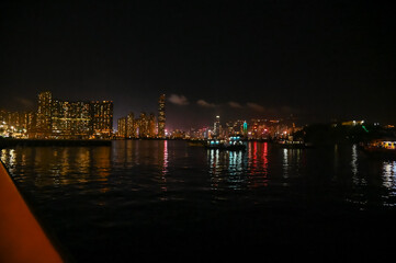 Fototapeta premium The night view of Hong Kong Island from the Kowloon. Hong Kong cityscape and seascape at night. Nature and city scene.