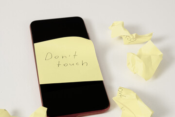 Smartphone with a “Do Not Touch” sticker: a symbol of a break from digital devices, reminding you of the importance of unplugging and taking a break