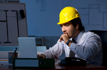 Young construction architect working on project at night