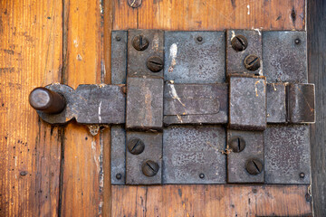 Antique door latch (lock) made of iron forged on a wooden door