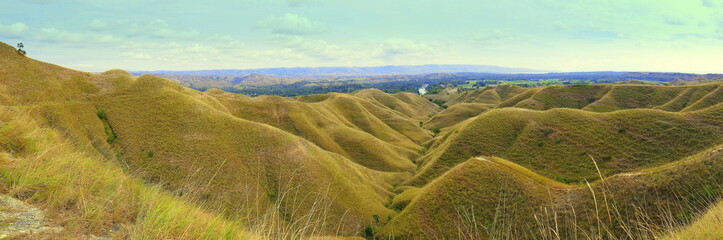 Landschaft nahe Waingapu in Sumba Indonesien mit braunen grasigen Bergen in der Trockenzeit