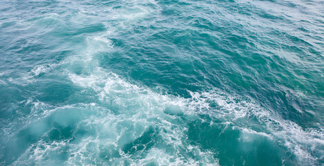 Fototapeta premium Ocean waves gently rolling in turquoise waters under bright daylight