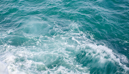 Fototapeta premium Waves crashing on a clear turquoise ocean under bright sunlight