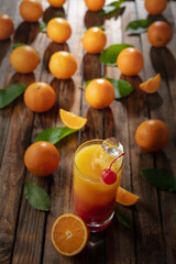 Tequila sunrise cocktail on an old wooden table.