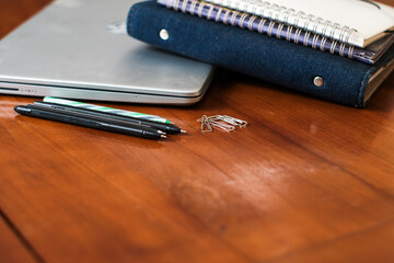 Workplace office with wooden table . Top view from above of Laptop, notebooks with pens and clips. Flat lay, Business-finance or education concept with copy space.