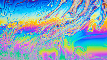 Colorful close-up of soap bubble showcasing interference phenomenon as vibrant colors ripple across the surface, creating a hypnotic display of light and beauty