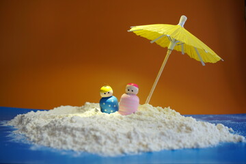 Shelter under an umbrella. Dolls that seek shelter and are together. Protection against rain or...