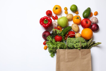 Delivery of vegetarian products. Bag with different vegetables and fruits on white background, top view