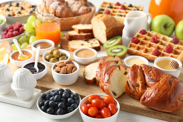 Different meals served for breakfast on white table