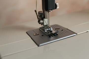 Modern sewing machine on light background, closeup