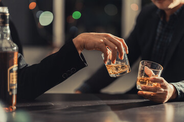Businessmen discussing work and drinking Vikis in a dark room, close-up photo