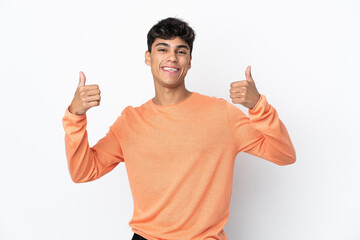 Fototapeta premium Young man over isolated white background giving a thumbs up gesture