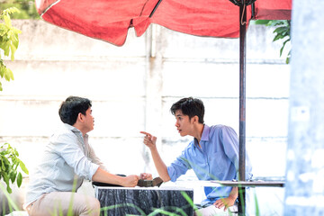 Two men arguing each other in the park, blame each other. Quarrel between two men