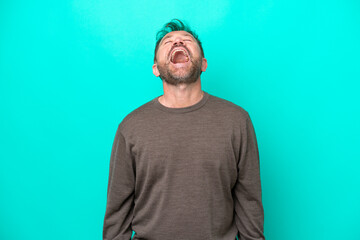 Middle age caucasian man isolated on blue background laughing