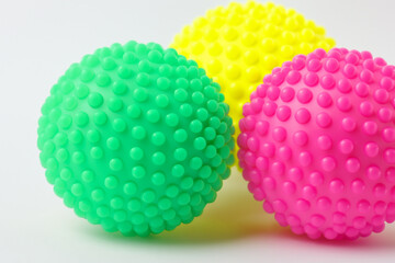 Dog is playing with spiky ball and other toys. medical child sport concept. game of ball with colored balls on a white . a dog playing a game of ball with colored balls on a white lifestyle.