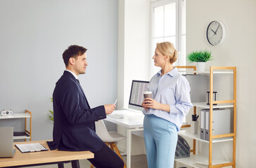 Two coworkers taking a coffee break together in the office, relaxing, and engaging in conversation. Resting fostering teamwork and bond, and discuss business matters in a more casual setting.