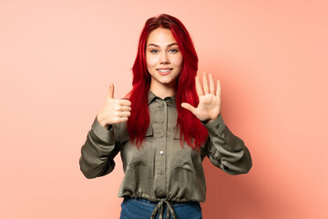 Teenager red hair girl isolated on pink background counting six with fingers