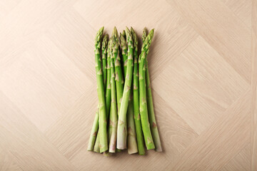 Fresh green asparagus stems on wooden table, top view