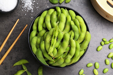 Raw green edamame soybeans and pods on grey table, flat lay
