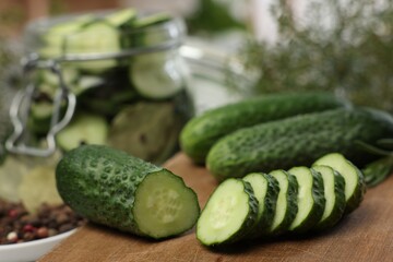 Board with fresh cut cucumber on blurred background, closeup
