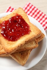 Delicious toasted bread slices with jam on table, closeup