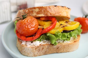 Tasty sandwich with grilled vegetables and cream cheese on table, closeup