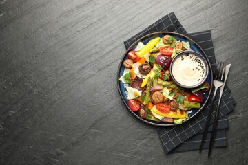 Delicious salad with grilled vegetables and sauce served on dark gray textured table, flat lay. Space for text