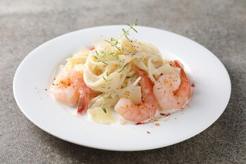 Delicious pasta with shrimps and cheese on grey table, closeup